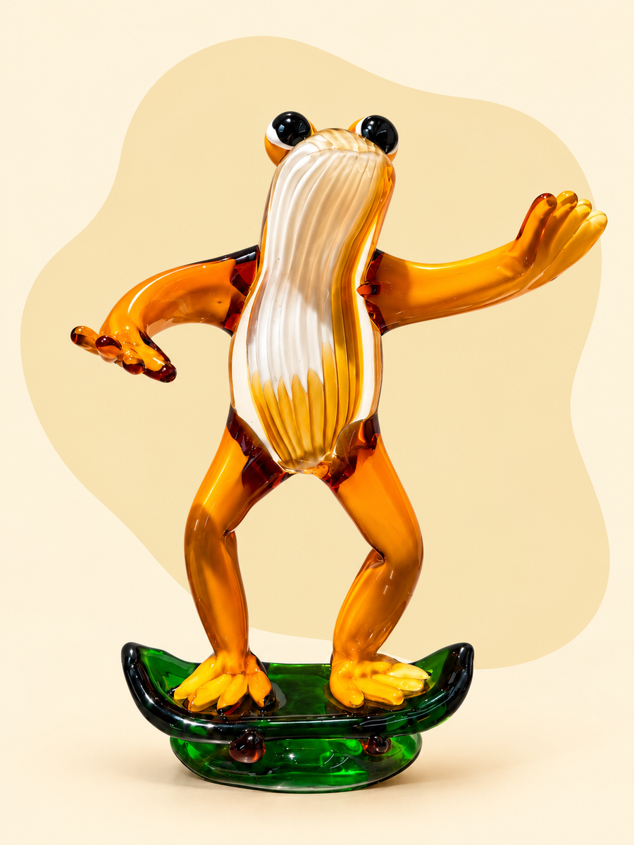 Glass frog on skateboard sculpture — front view